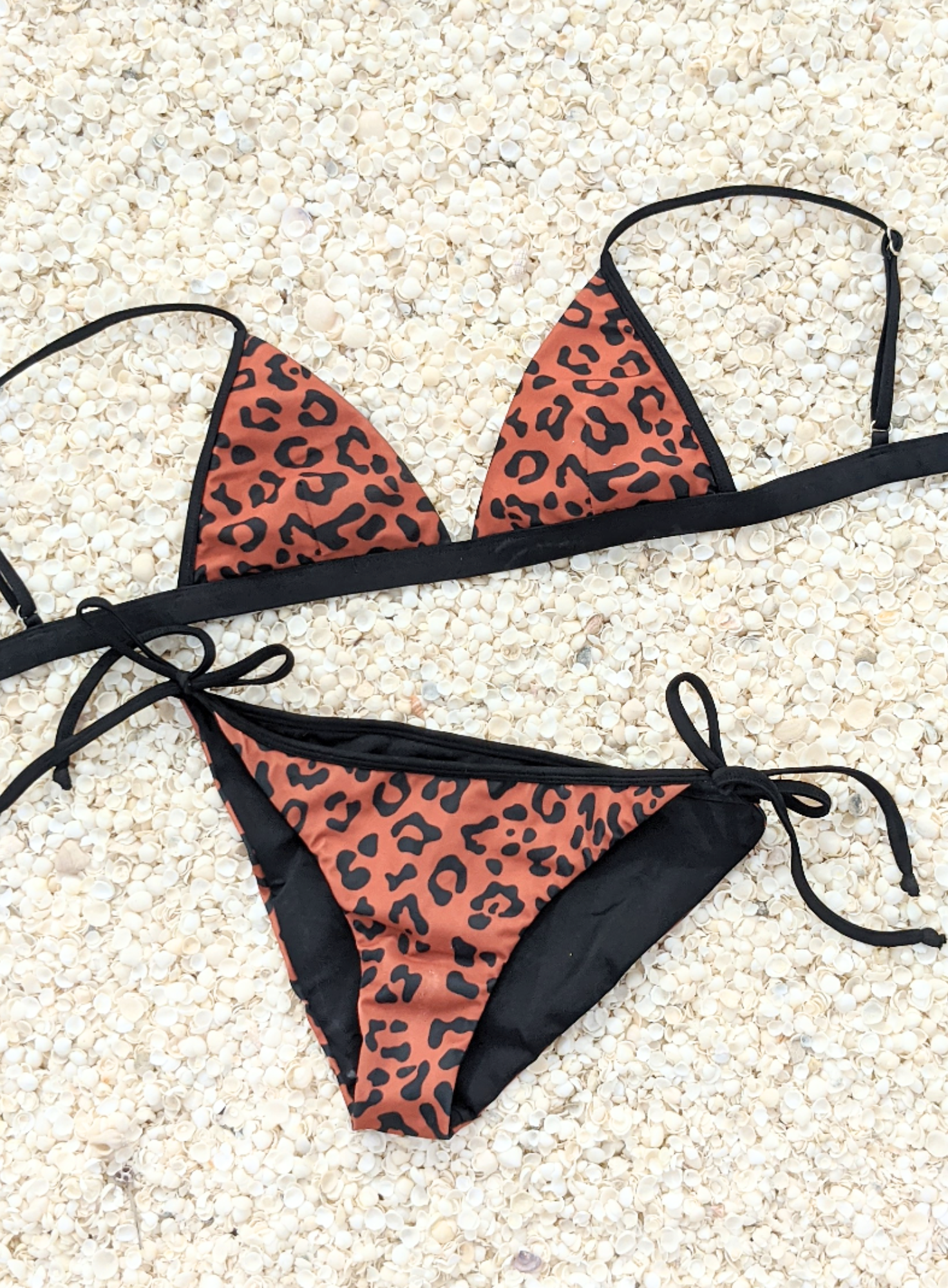 Sustainable swimwear reversible bikini in black and leopard print tie side classic cut bikini bottom flat lay