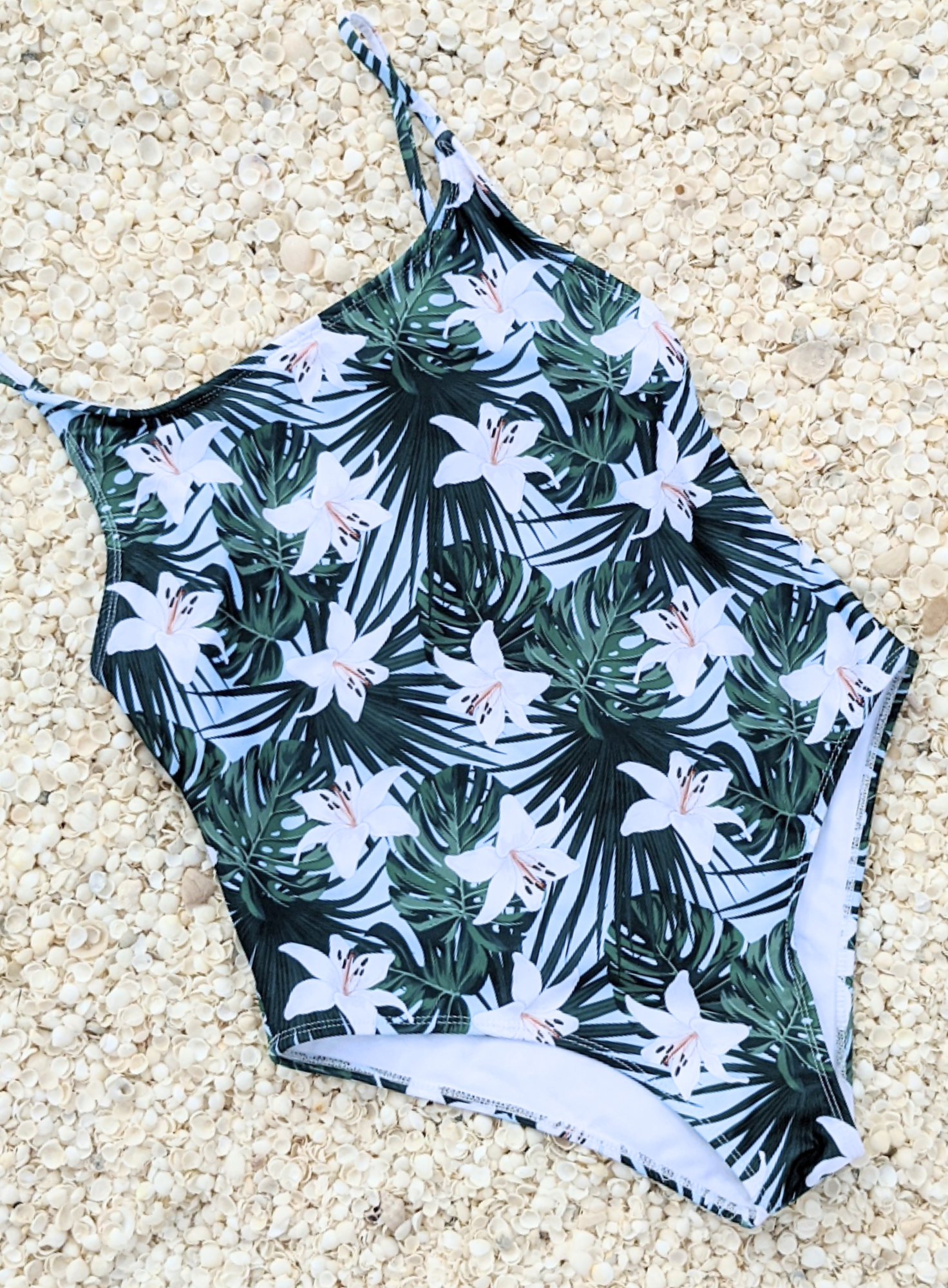 Sustainable swimsuit One Piece Swimwear with a Blue Floral Print, Thin Straps Classic Cut And High Cut Leg flat lay
