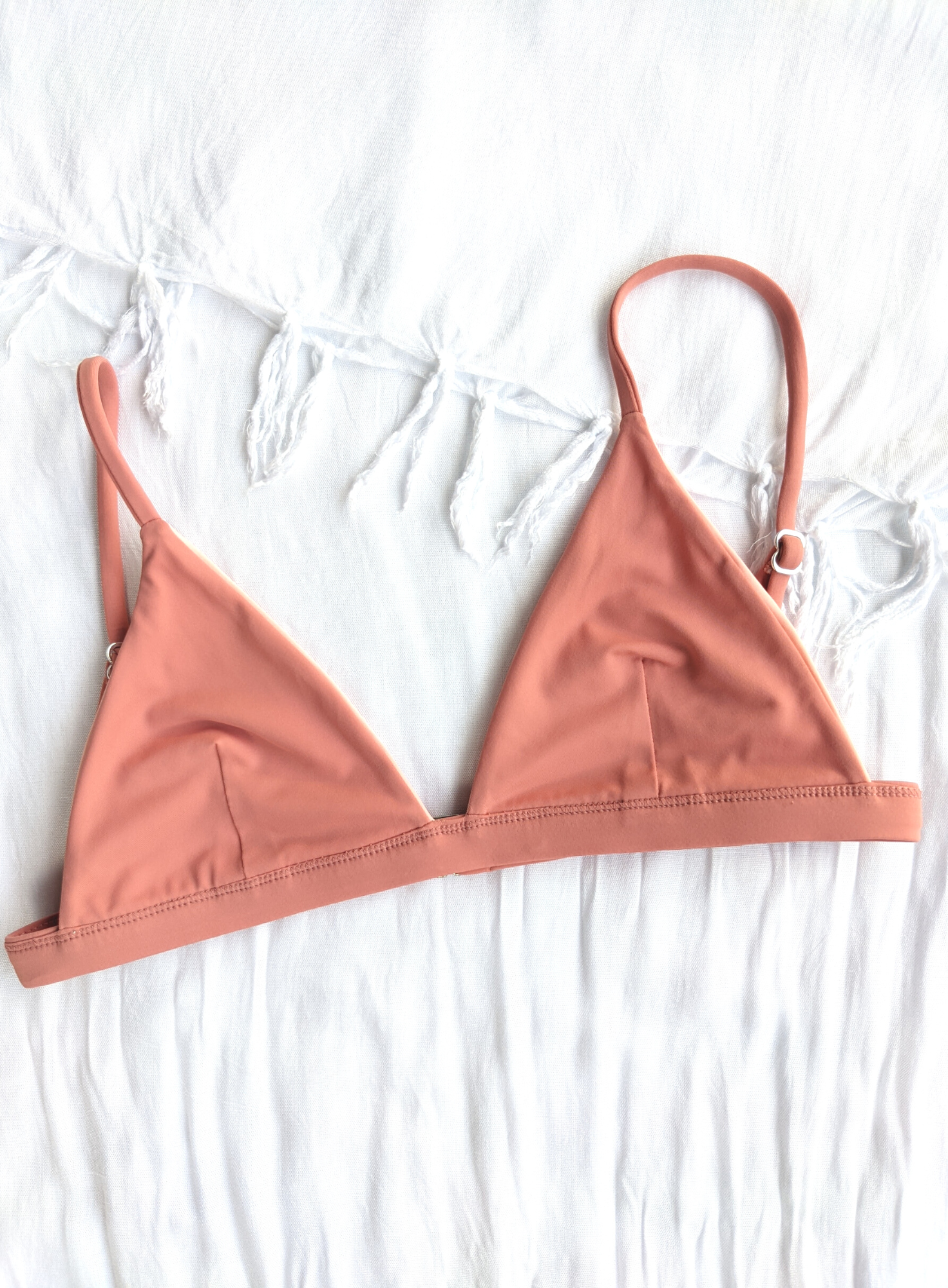 Sustainable swimwear reversible bikini top in blush and peach flat lay blush side
