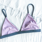 Sustainable swimwear reversible bikini top in blue and purple flat lay on the purple side