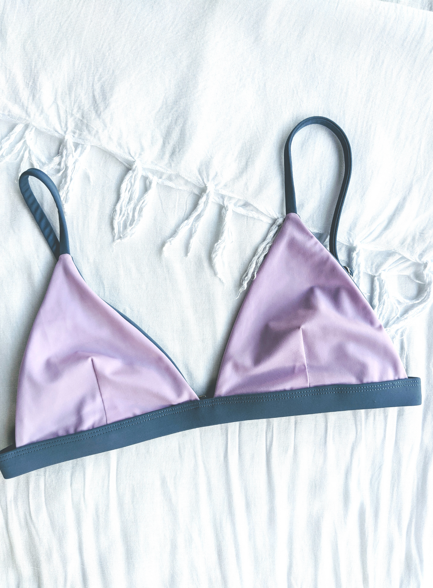Sustainable swimwear reversible bikini top in blue and purple flat lay on the purple side