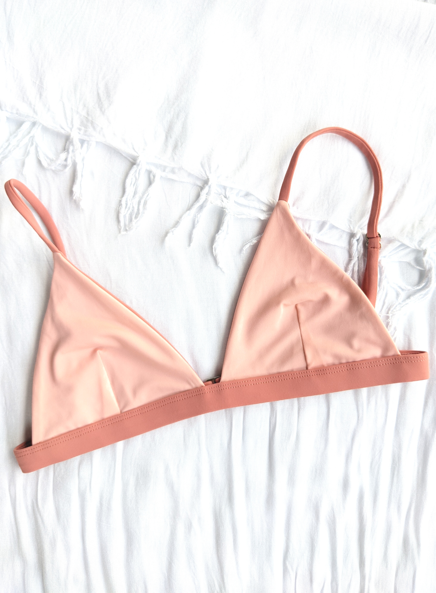 Sustainable swimwear reversible bikini top in blush and peach flat lay peach side