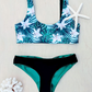 Sustainable swimwear reversible bikini top in black and floral print flat lay