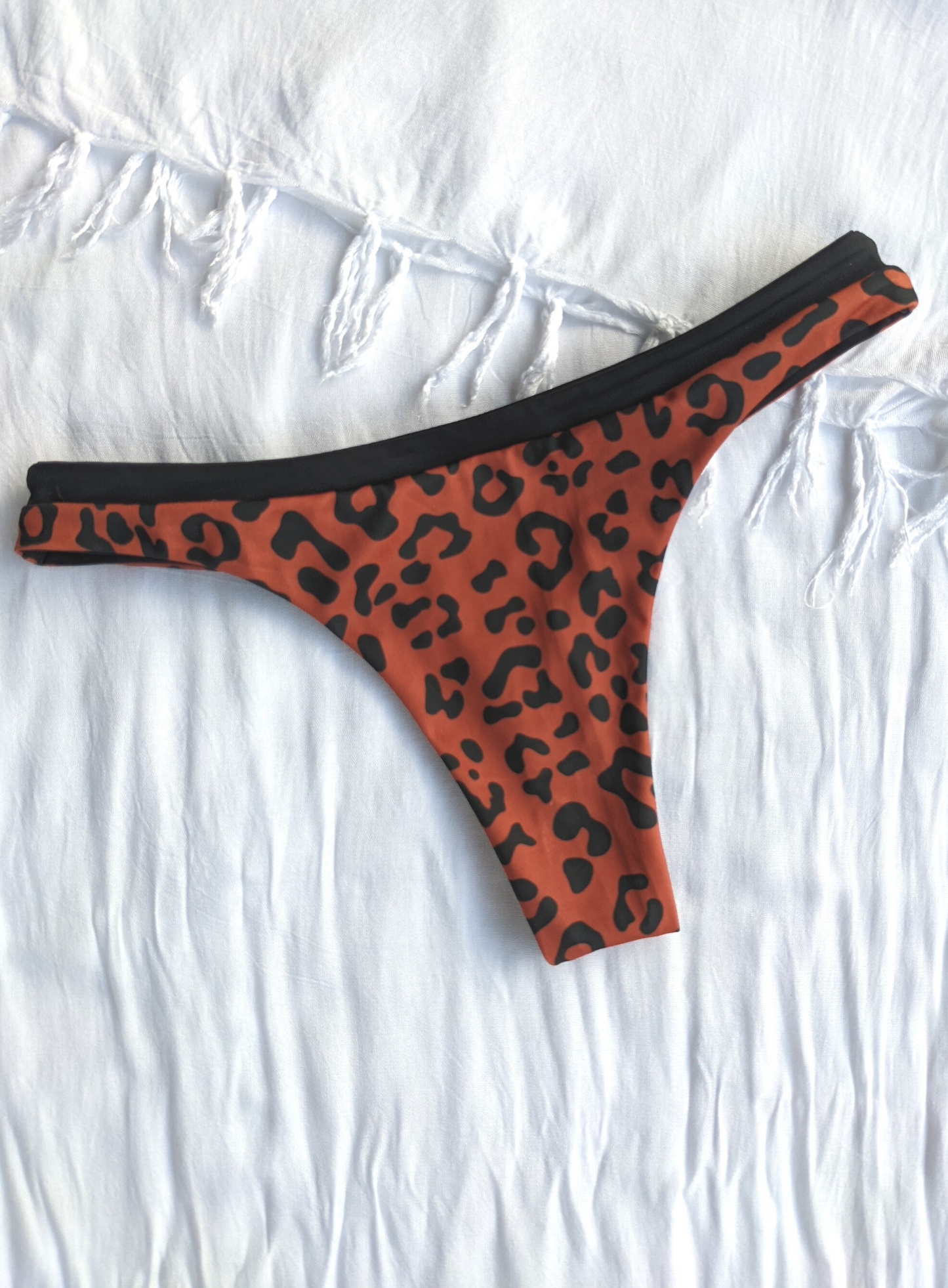 Reversible Black and Leopard Print Skimpy Cut Bikini Bottom Made From Eco Friendly Recycled Regenerated Nylon Fabric Leopard Print Front Flat Lay View
