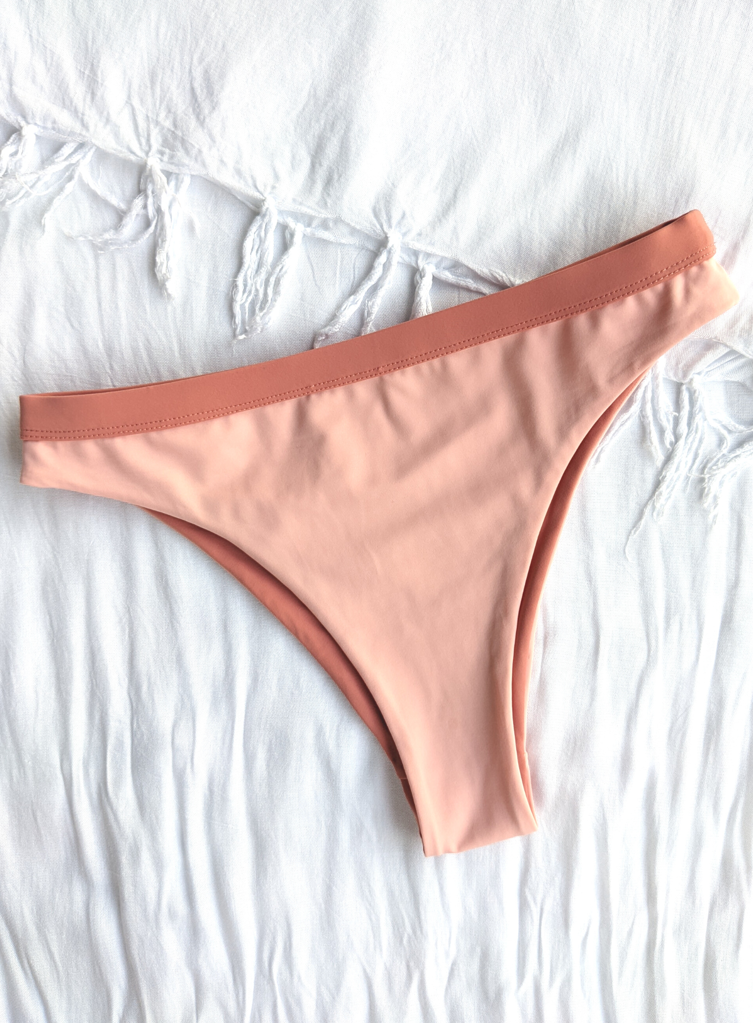 Reversible Blush and Peach Medium High Cut Bikini Bottom Made From Eco Friendly Recycled Regenerated Fabric Peach Front Flat Lay View